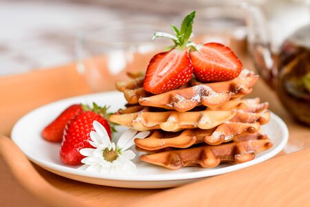 Delicious fresh baked belgian waffles with berries and fruit on a concrete backgroundの写真素材