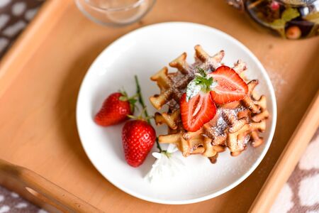 Delicious fresh baked belgian waffles with berries and fruit on a concrete backgroundの写真素材