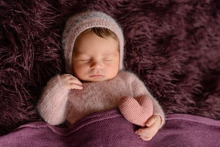 A little newborn girl eight days old in a beautiful outfit sleeps cuteの写真素材