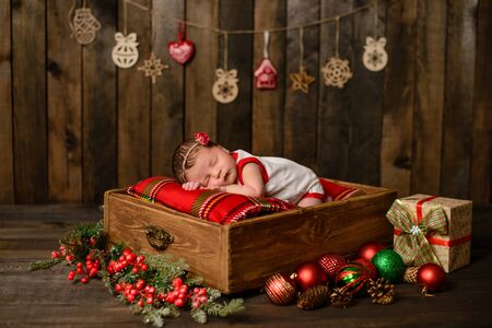 Little newborn girl eight days old in Christmas suit who sleeps nicelyの写真素材