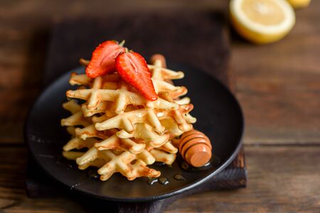 Delicious fresh baked belgian waffles with berries and fruit on a concrete backgroundの写真素材