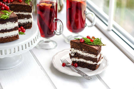 Beautiful delicious cake with bright red berries on the  table with fragrant mulled wineの写真素材