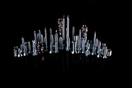 Metal steel nuts laid in composition on a black background