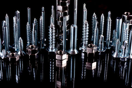 Metal steel nuts laid in composition on a black background