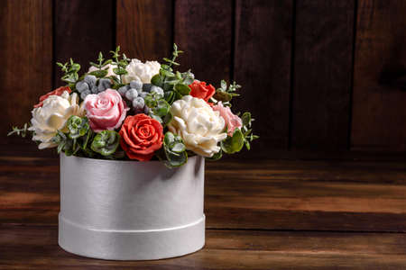 Bouquet of beautiful bright rose flowers in a gift cylindrical cardboard box. Gift bouquet of soap...