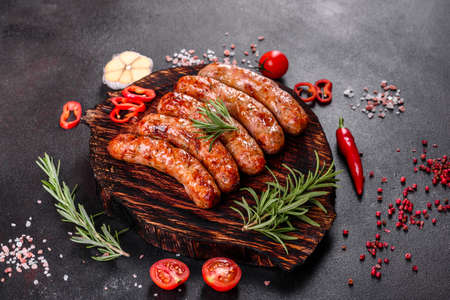 Fresh juicy sausages grilled with tomatoes, spices and herbsの写真素材