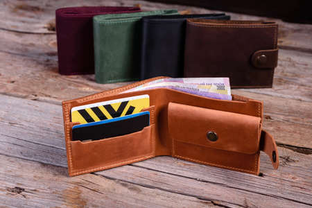 Stylish leather wallet with money and box on wooden background