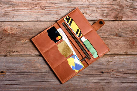 Stylish leather wallet with money and box on wooden background
