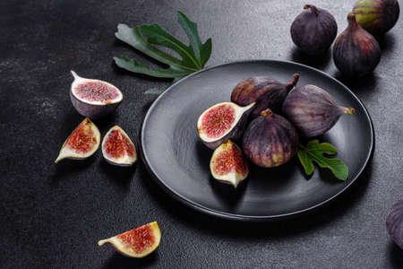 Fresh ripe figs on dark table. Healthy mediterranean fig fruit. Fresh figs on black backgroundの写真素材