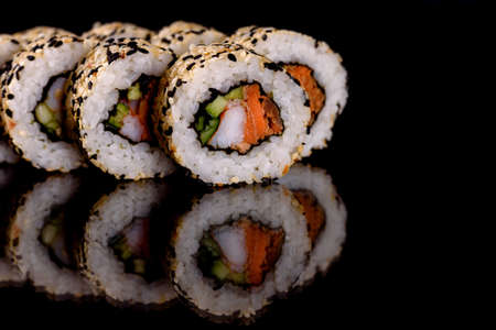 Fresh delicious beautiful sushi rolls on a dark background. Elements of Japanese cuisine