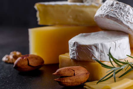 Beautiful delicious camembert cheese, parmesan, brie with grapes and figs on a wooden board. Snacks for wine on holidayの写真素材
