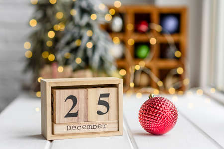 Beautiful multi-colored Christmas decorations on a light wooden table with garlands and Christmas...