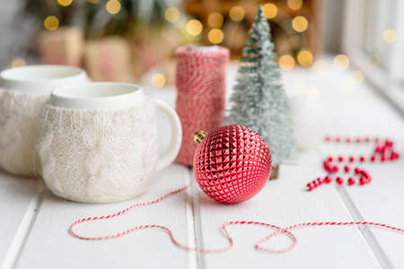 Beautiful multi-colored Christmas decorations on a light wooden table with garlands and Christmas...