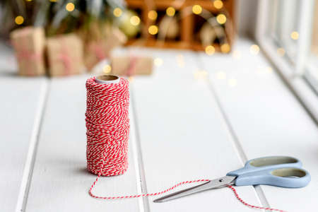 Beautiful multi-colored Christmas decorations on a light wooden table with garlands and Christmas...