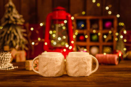 Beautiful multi-colored Christmas decorations on a wooden table with garlands and Christmas trees in the background. Preparing for the holidayの写真素材