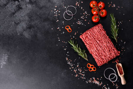 Fresh raw beef mince on a dark background. Preparation for cooking of cutletsの写真素材