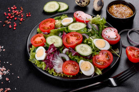 Fresh delicious vegitarian salad of chopped vegetables on a plate on a dark concrete backgroundの写真素材
