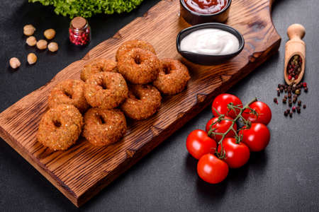 Beautiful delicious fresh chickpea falafel with sauces on a concrete background. Elements of...