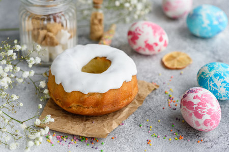 Festive cakes with white glaze, nuts and raisins with Easter eggs on the festive table. Preparations...