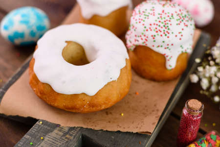 Festive cakes with white glaze, nuts and raisins with Easter eggs on the festive table. Preparations for Easterの写真素材