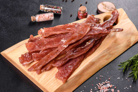 Tasty hearty meat salted and dried with pieces of spices and herbs. Fast and hearty snackの写真素材