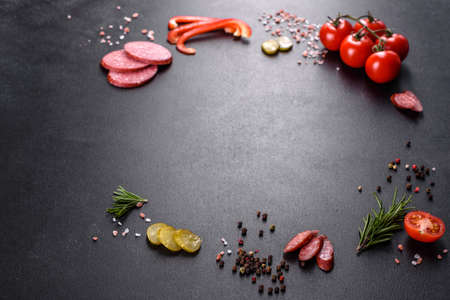 Ingredients for making pizza with sausage tomatoes and cheese in a hearth oven. Mediterranean cuisineの写真素材