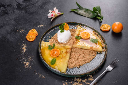 Delicious fresh pancakes on a plate with sweet sauce and ice cream decorated with mint. Delicious hearty breakfastの写真素材