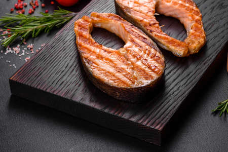 Fresh cooked delicious salmon steak with spices and herbs baked on a grill. Healthy seafood foodの写真素材