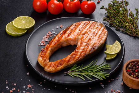 Fresh cooked delicious salmon steak with spices and herbs baked on a grill. Healthy seafood food