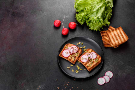 Delicious crisp sandwich with toast, radish, pumpkin seeds and flax seeds. Vegitarian foodの写真素材