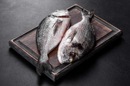 Raw dorado fish on cutting board.の写真素材