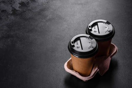 Disposable dishes made of environmentally friendly brown cardboard on a dark background. Food delivery in disposable dishesの写真素材