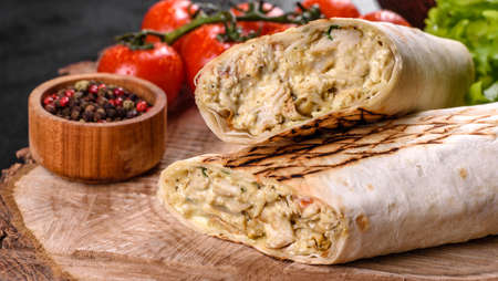 Delicious fresh shawarma with meat and vegetables on a dark concrete table. Fast food, Turkish...