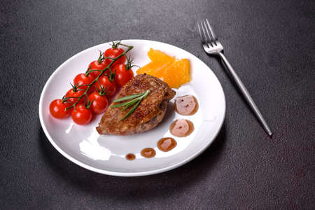 Baked duck breast with herbs and spices on a dark concrete background. Fried meat ready to eatの写真素材