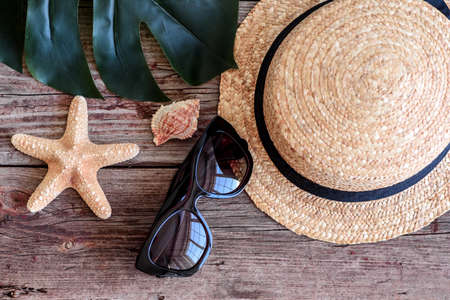 Beach accessories: glasses and hat with shells and sea stars on a colored background. Summer backgroundの写真素材