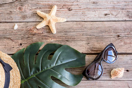 Beach accessories: glasses and hat with shells and sea stars on a colored background. Summer backgroundの写真素材