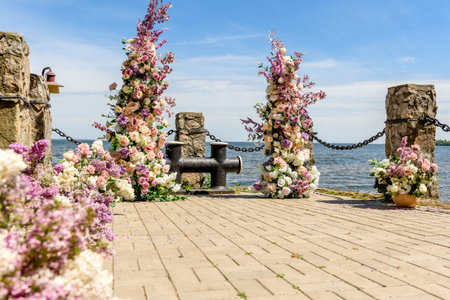 Beautiful floral composition for an away wedding ceremony on the ocean coast. Solemn ceremony of painting the groom and brideの写真素材
