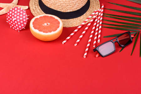 Beach accessories: glasses and hat with shells and sea stars on a colored background. Summer...