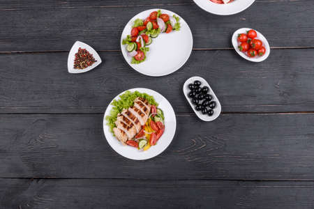 Three fresh delicious salads with chicken, tomato, cucumber, onions and greens with olive oil....