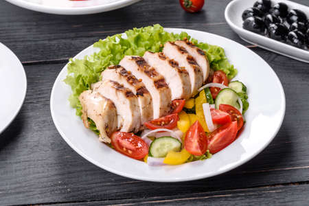 Fresh delicious salad with chicken, tomato, cucumber, onions and greens with olive oil. Summer menu saladsの写真素材
