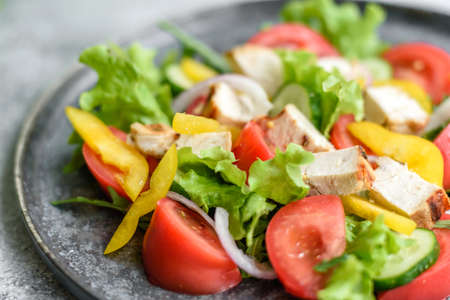Fresh delicious salad with chicken, tomato, cucumber, onions and greens with olive oil. Summer menu...
