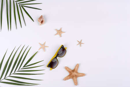 Beach accessories: glasses and hat with shells and sea stars on a white background. Summer backgroundの写真素材