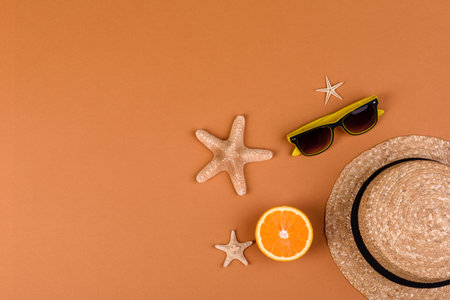 Beach accessories: glasses and hat with shells and sea stars on a colored background. Summer...