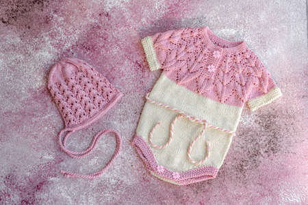 Knitted clothes made of natural wool threads for a newborn baby. Outerwear for the smallest
