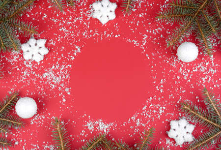 Christmas composition. Christmas red decorations, fir tree branches on red background. Flat lay, top view, copy spaceの写真素材