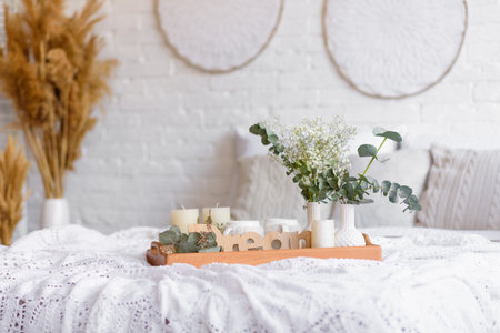 Beautiful home interior with white and beige tones, with dream catchers, dry flowers and a bed. Interior of a cozy houseの写真素材