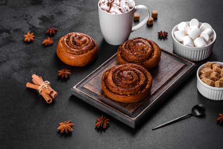 Freshly baked cinnamon roll with spices and cocoa filling on a black background. Cinnabon buns. Swedish breakfast.の写真素材