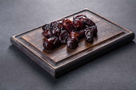Beautiful delicious dates on a dark concrete background. Tasty healthy fruitの写真素材
