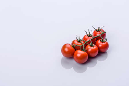 Bunch of fresh, red tomatoes with green stems isolated on white background. Clipping pathの写真素材