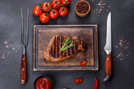 Cooked grilled Chuck eye roll steak on a chopping Board. Dark backgroundの写真素材
